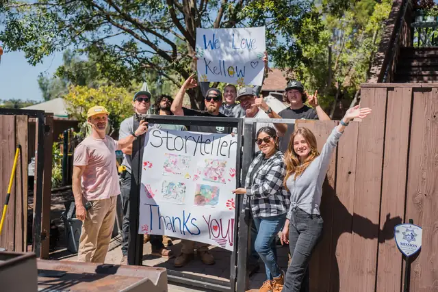 The Kellow Construction crew holding a thank-you banner at a Building Together project