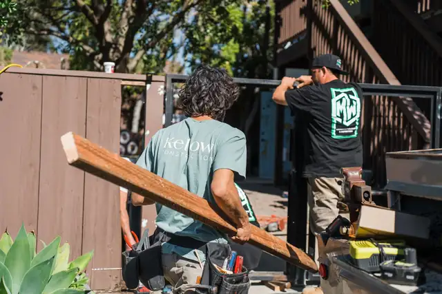 Kellow Construction carpenters carrying lumber on a job site