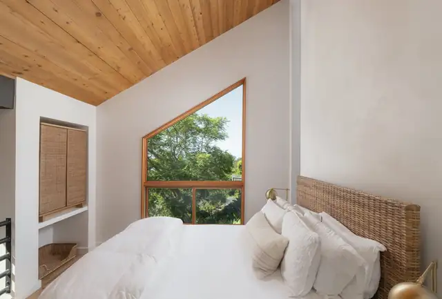Bedroom remodel with a wood ceiling, angled picture window and built-in closet