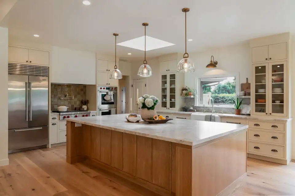 Kitchen remodeling Santa Barbara area: Montecito kitchen with a white oak island, marble countertops, glass pendants and a skylight